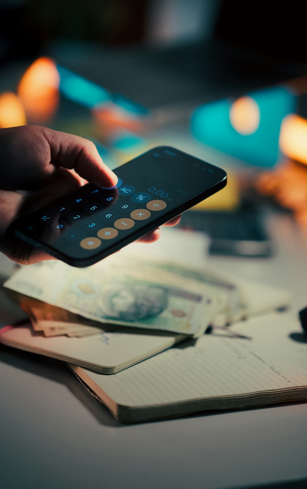 smartphone calculator zloty banknotes budget notebook Close-up person using mobile calculator